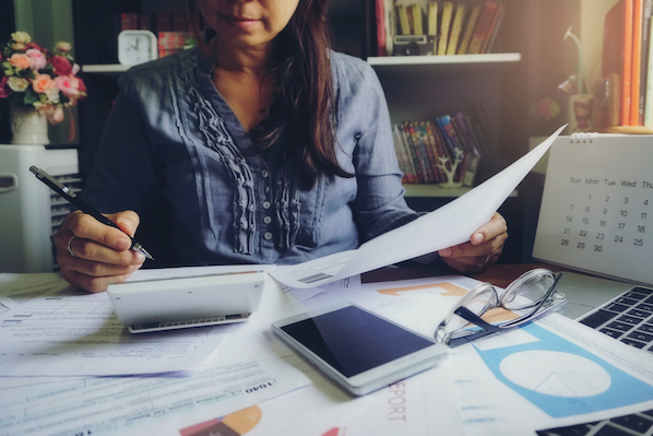 woman analyzing her company's marketing budget for 2021, and determining a budget percentage out of total company-wide budget.