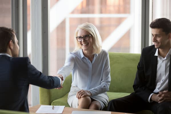 A sales executive shakes hands and lands a deal with a client after using sales mirroring.