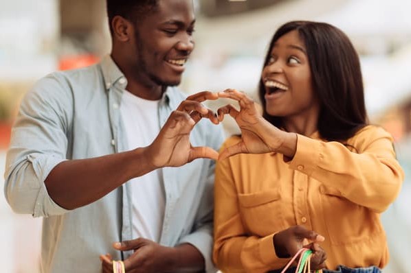 A couple puts their hands together to form a heart as part of a Valentine's Day marketing campaign. 